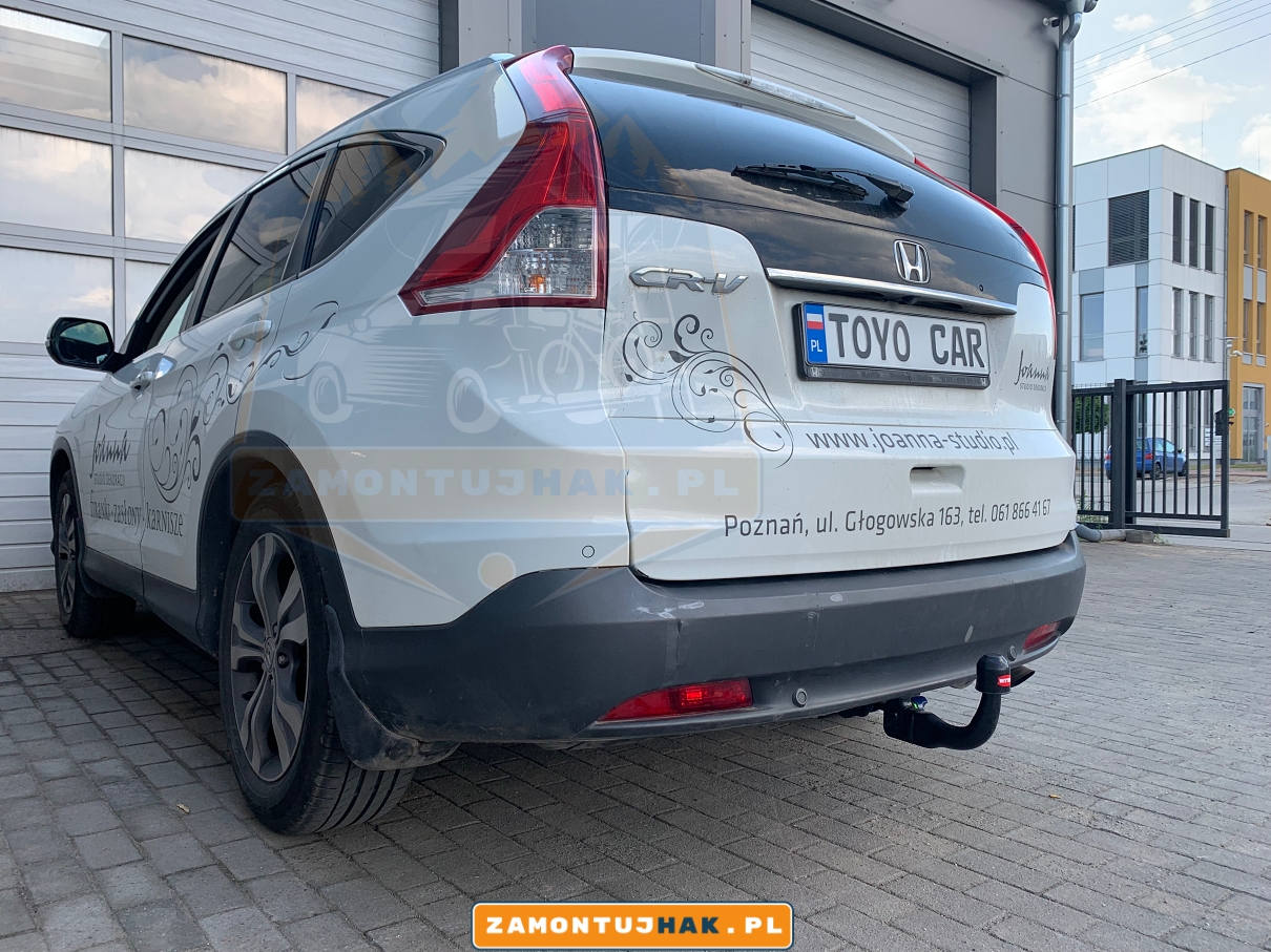 Zdjęcie przedstawia Hondę CR-V z zamontowanym wypinanym pionowo hakiem holowniczym westfalia a40v, zdjęcie jest zrobione z tyłu, z lewej strony samochodu.